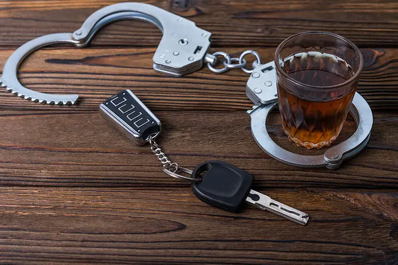 A car key handcuff and glass with liquor.