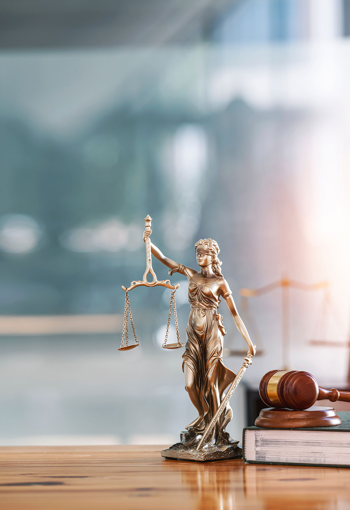 justice scale and gavel with sound block on top of a wooden table.