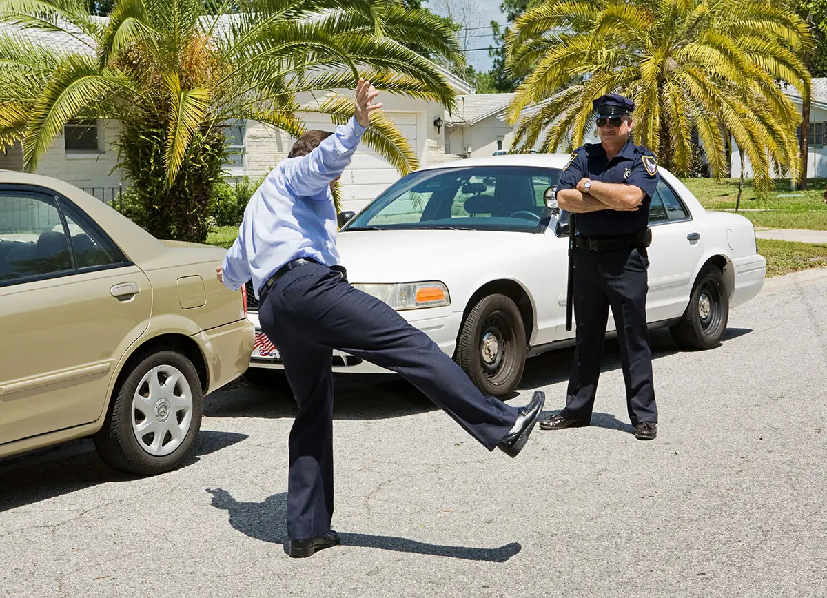A police officer instructs a driver suspected of drunk driving to perform a one-leg stand test.