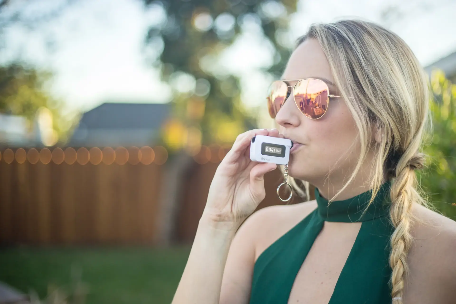A woman takes a breathalyzer test using a BACtrac monitor.