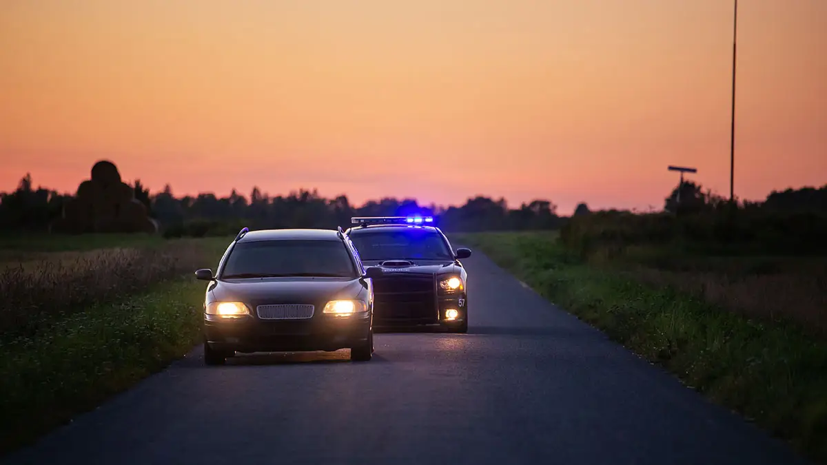 A police car signals a car in front to pull over.
