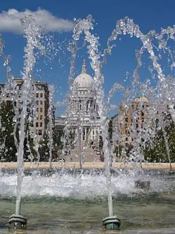 a water fountain in a park with the Wisconsin City Hall in the background.